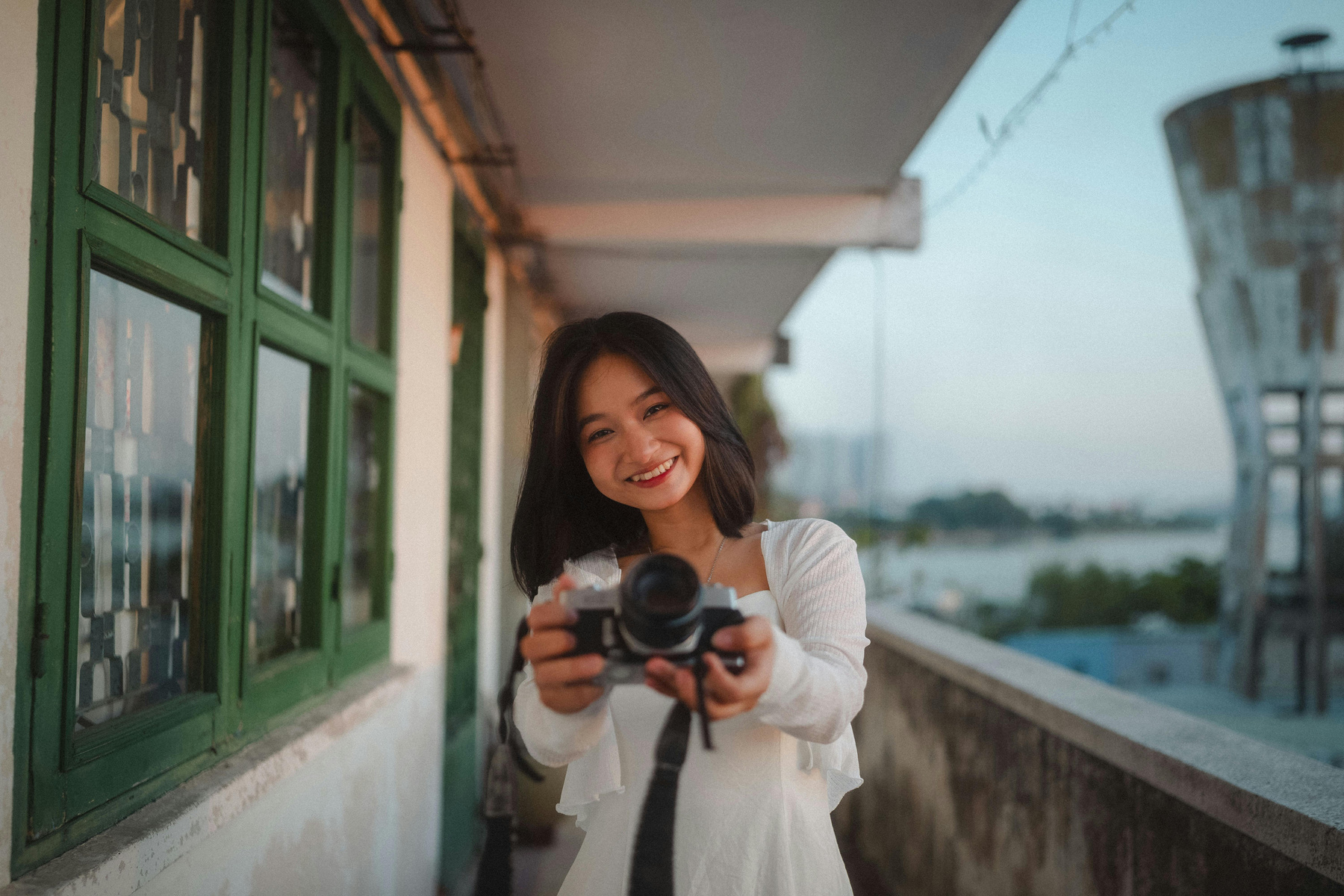 A woman holding a camera and smiling